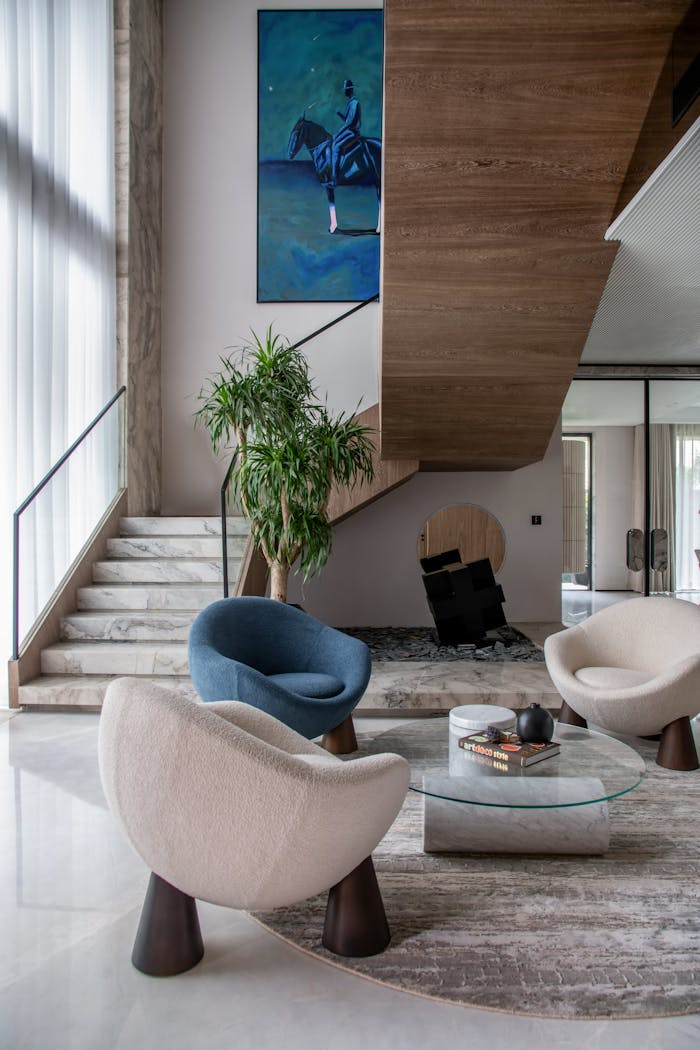creative-03 Elegant modern living room featuring unique chairs, art, and staircase for luxury appeal.